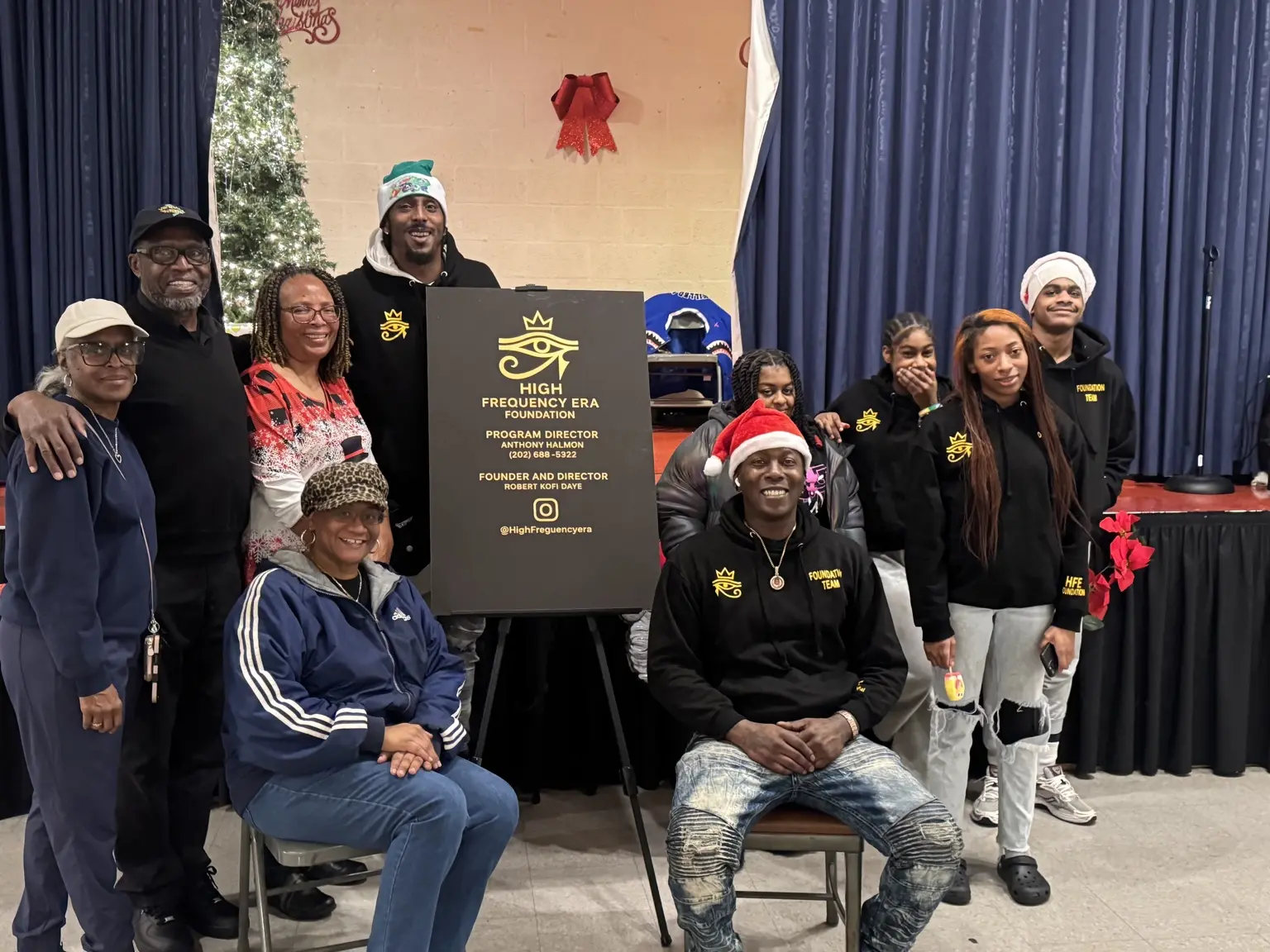 High Frequency Era Foundation volunteers gathered around the foundation sign at the 2025 Holiday Experience